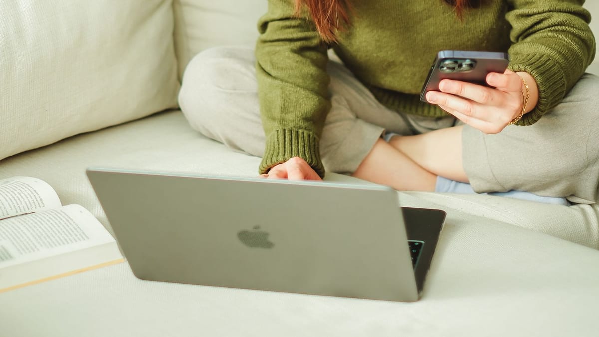 Young woman with a laptop and phone at home